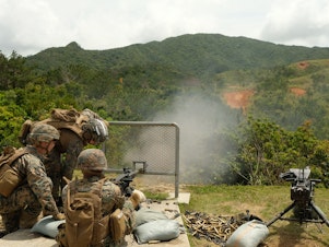 caption: Marines of the 12th Marine Littoral Regiment practice with .50-caliber machine guns on a firing range on Okinawa.