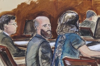 caption: In this courtroom sketch, Joshua Schulte (center) is seated at the defense table flanked by his attorneys on March 4, 2020, in New York.