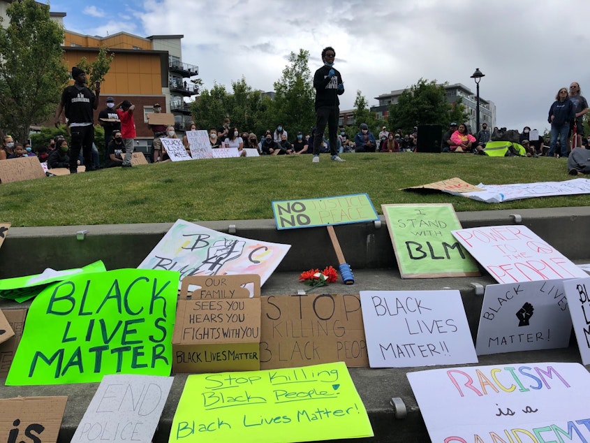 caption: Youth leader Mohammed Jama tells a crowd in Burien "Our freedoms are connected."