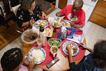 caption: Nicole Boynes, 46, has dinner with her daughters, Sierra, 13, and Gabrielle, 10, and her mother-in-law, Germaine Boynes, 77, at their house in Silver Spring, MD on March 7, 2022. (Shuran Huang for The Washington Post via Getty Images)
