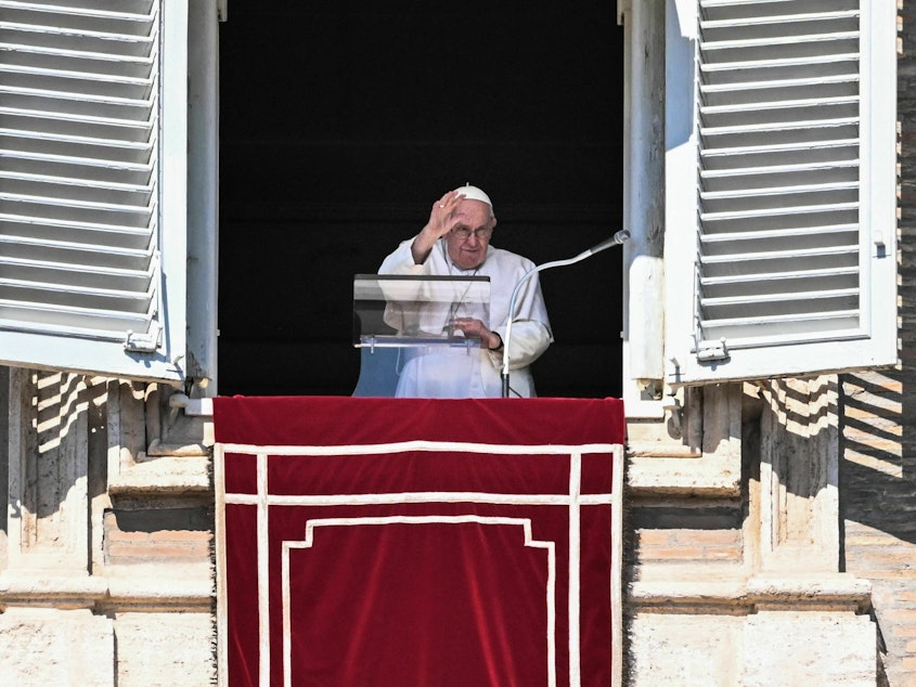caption: Pope Francis waves from the window of the apostolic palace during the weekly Angelus prayer on Sunday in the Vatican.