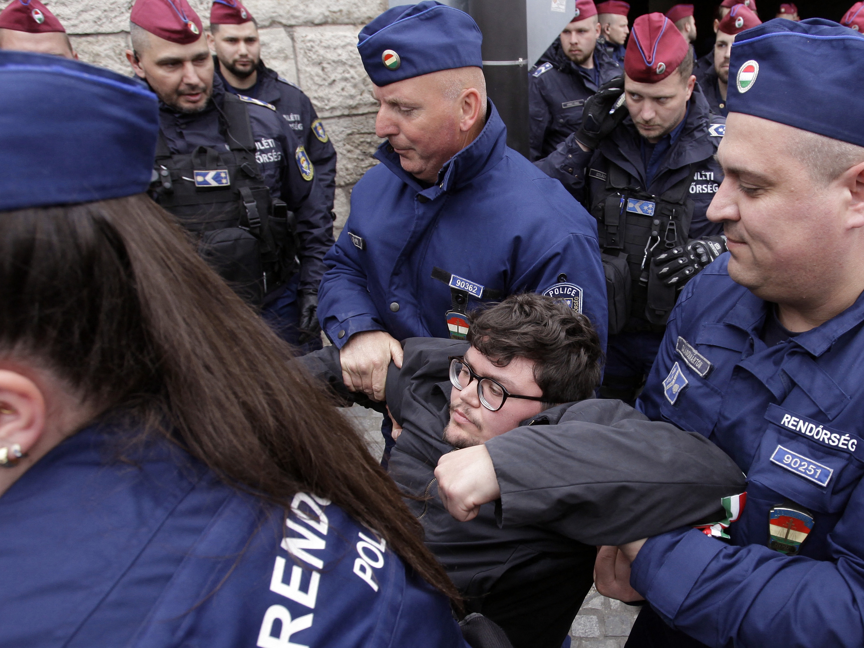 caption: Hungarian police remove a protester blocking the entrance of the Parliament building in Budapest on April 14, as Hungarian lawmakers were expected to approve constitutional changes further clamping down on rights for certain groups, part of Prime Minister Viktor Orbán's "Easter cleanup" against his domestic opponents.