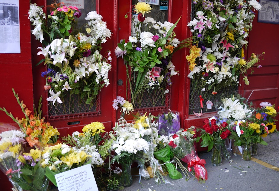caption: Flowers are piled outside the International District Emergency Center on Thursday in tribute to Donald Chin, who was shot to death earlier in the day.