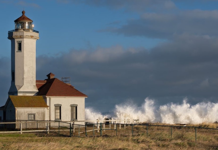 caption: Waves break at the Point Wilson Lighthouse in Port Townsend during a king tide on Dec. 8.