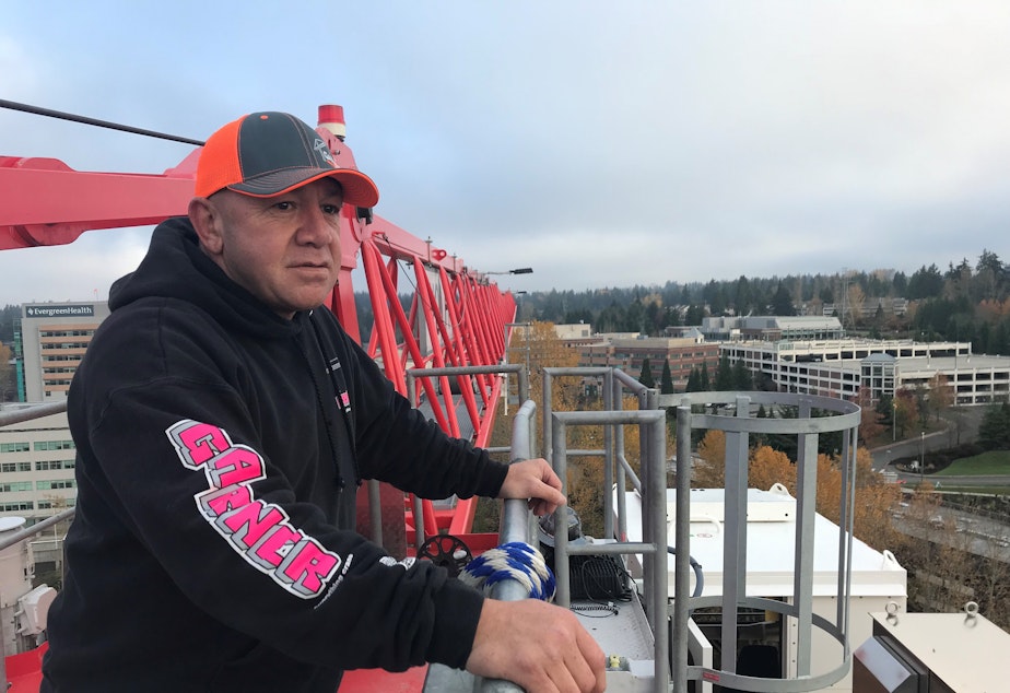 Bruce Tamblin stands at the top of his crane at a construction site in Kirkland. He has been putting holiday lights on his crane for over a decade.