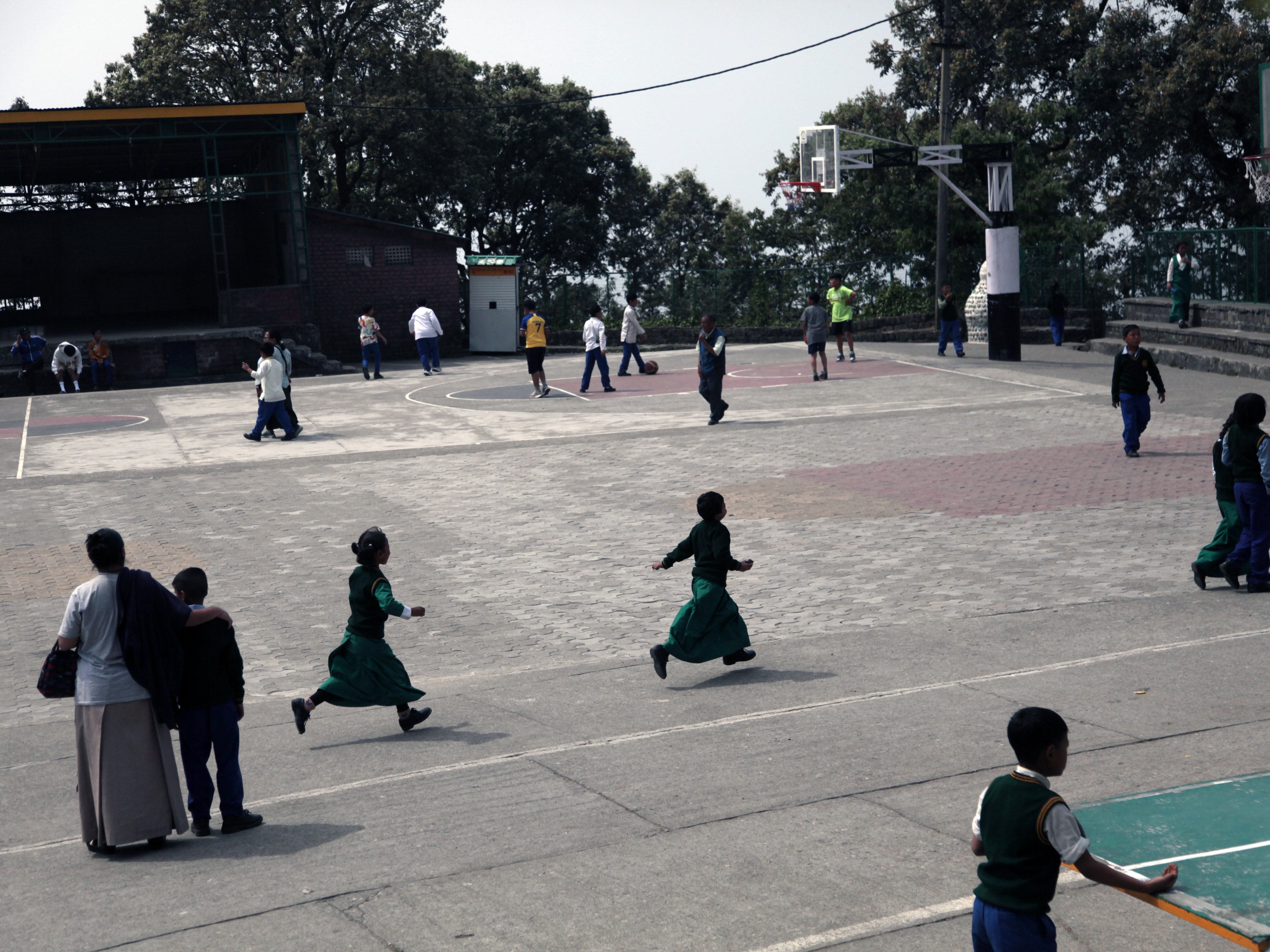 caption: Students run on the sports ground at the Tibetan Children's School in Dharamshala, a steep, alpine Himalayan city in northern India. It's the de facto capital of Tibetans in exile. School enrollment is shrinking, echoing the fate of the exile community itself.