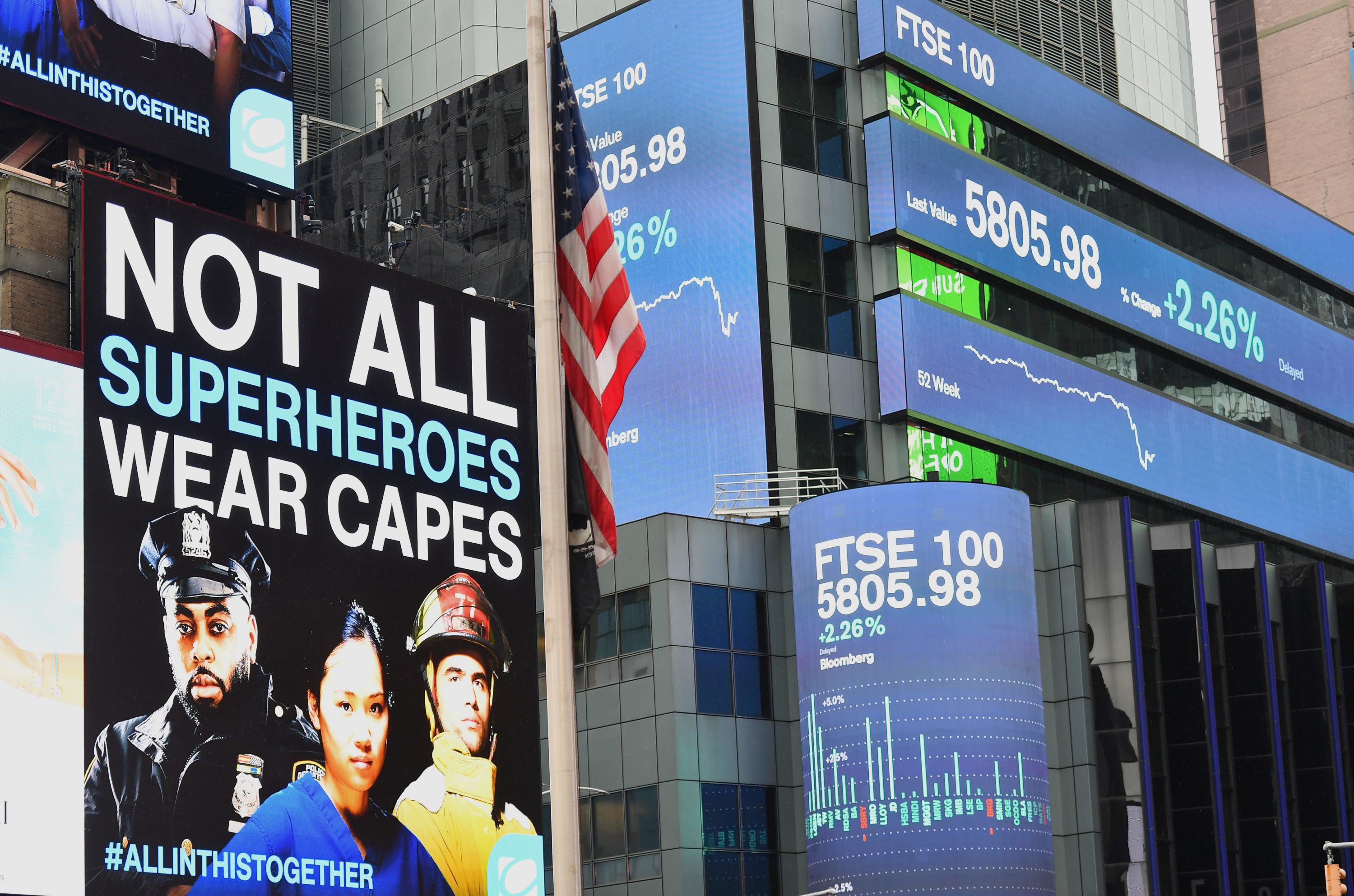 caption: Digital billboards and a US Flag at half-mast at Time Square on April 09, 2020 in New York City. (ANGELA WEISS/AFP via Getty Images)