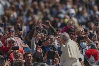 caption: Pope Francis on his popemobile drives through the crowd of faithful at the end of the Catholic Easter Sunday mass he led in St. Peter's Square at the Vatican, Sunday, April 17, 2022.
