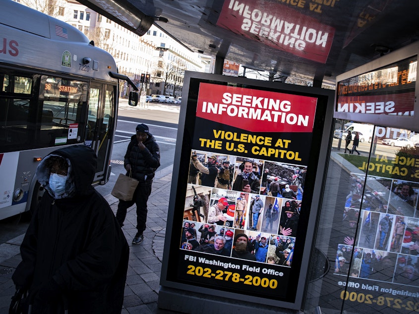 caption: At a bus stop on Pennsylvania Avenue Northwest in Washington, D.C., a notice from the FBI seeks information about people pictured during the riot at the U.S. Capitol on Wednesday.