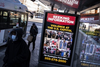 caption: At a bus stop on Pennsylvania Avenue Northwest in Washington, D.C., a notice from the FBI seeks information about people pictured during the riot at the U.S. Capitol on Wednesday.