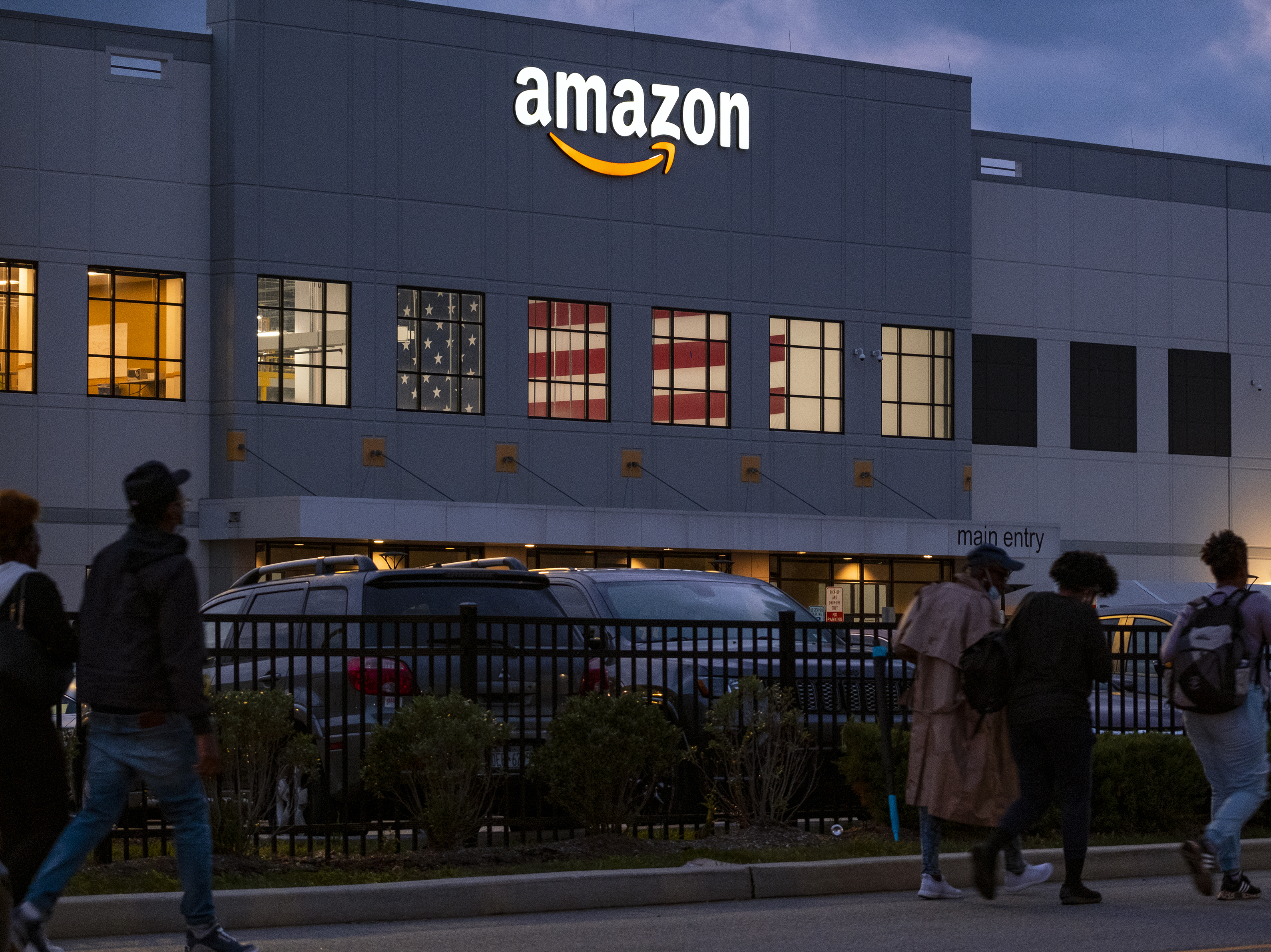 caption: People arrive for work at the Amazon distribution center in the Staten Island borough of New York on Oct. 25. The National Labor Relations Board is confirming that a group of Amazon warehouse workers in Staten Island has withdrawn its petition to hold a vote to unionize.