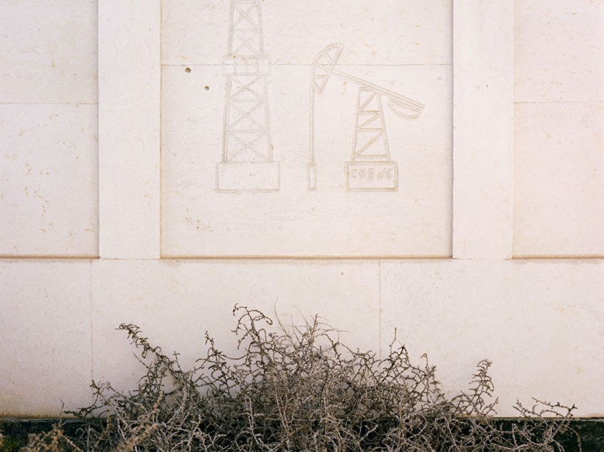 caption: Oil rig and "nodding donkey" (oil pumping jack) engraved into the side of a mausoleum to commemorate a man who made his fortune in the Caspian oil industry. Koshkar-Ata, Kazakhstan, 2010.