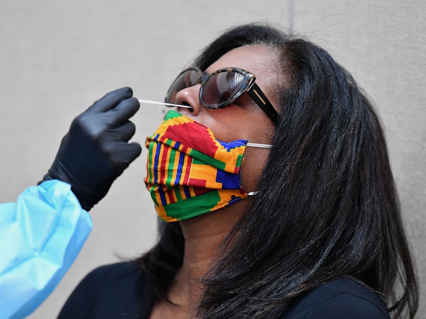 caption: A woman is tested for the coronavirus at Harlem's Abyssinian Baptist Church in New York City.