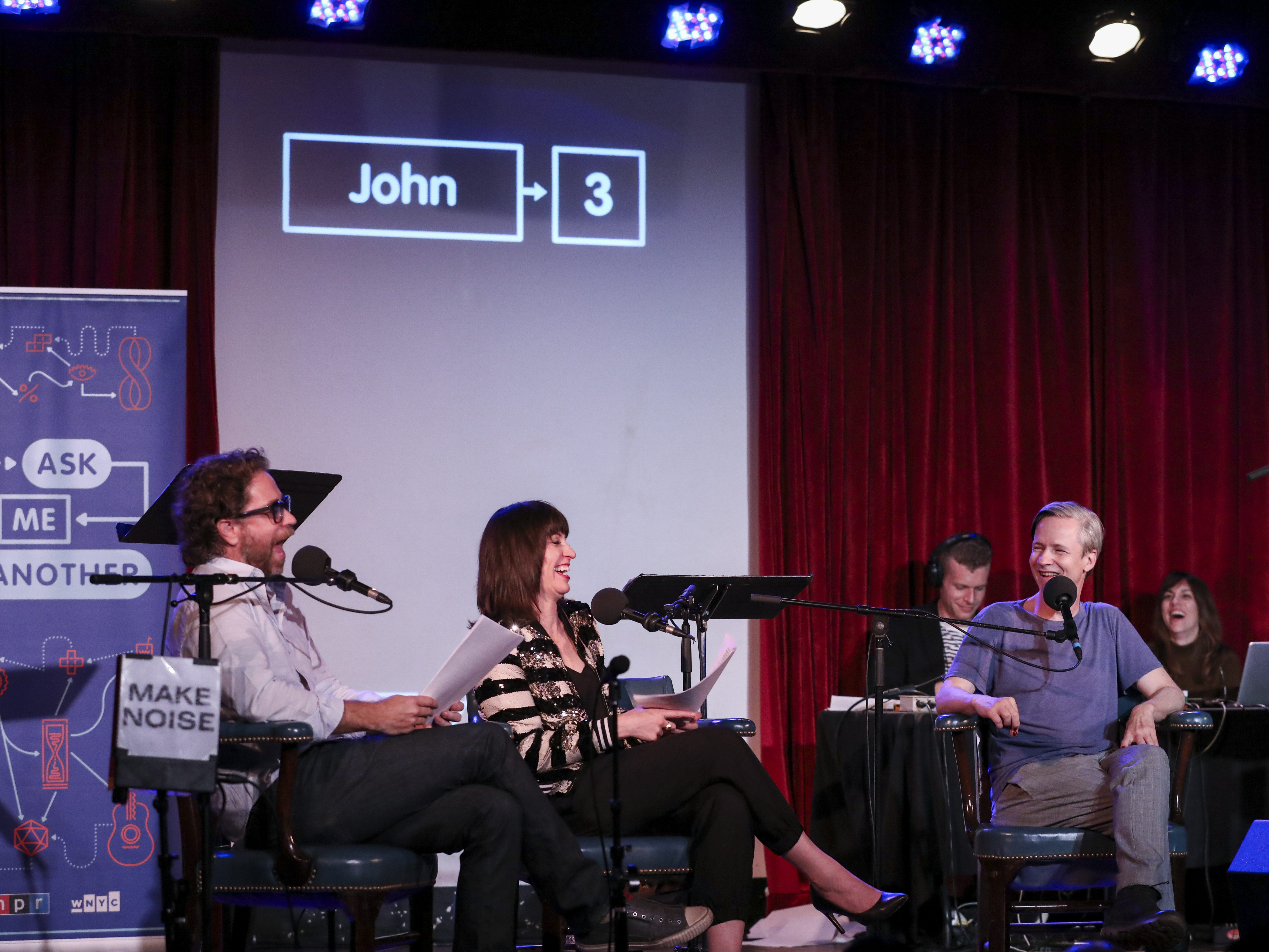 caption: John Cameron Mitchell plays a game with Jonathan Coulton and Ophira Eisenberg on <em>Ask Me Another</em> at the Bell House in Brooklyn, New York.