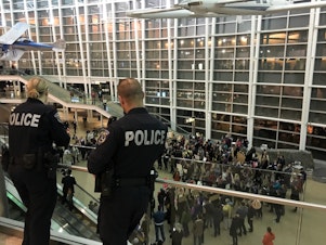 caption: Police look out over a growing protest at Sea-Tac International Airport, where up to 13 people have been detained one day after President Donald Trump issued an executive order banning people from seven Muslim countries.