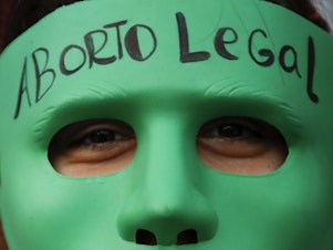 caption: An abortion-rights activist wears a mask with text that reads in Spanish "Legal Abortion" during a rally outside Congress as lawmakers debate a bill that would legalize abortion, in Buenos Aires, Argentina, Tuesday, Dec. 29, 2020.