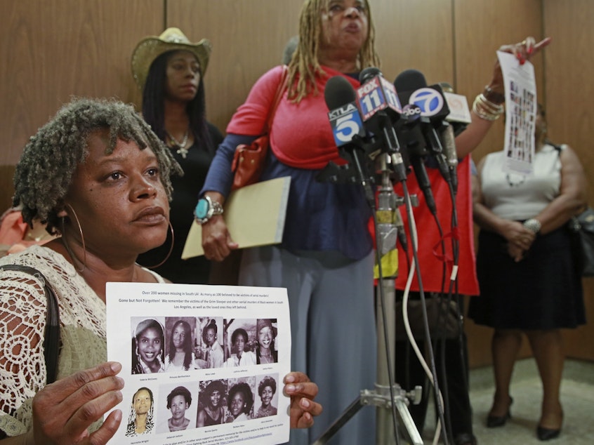 caption: Black Coalition Fighting Back Serial Murders members Suzette Shaw, left, holding photos of 10 victims, and Margaret Prescod, at podium, join relatives of victims speaking after the sentencing for Lonnie Franklin Jr., a convicted serial killer known as the "Grim Sleeper," in Los Angeles Superior Court in August 2016.