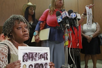 caption: Black Coalition Fighting Back Serial Murders members Suzette Shaw, left, holding photos of 10 victims, and Margaret Prescod, at podium, join relatives of victims speaking after the sentencing for Lonnie Franklin Jr., a convicted serial killer known as the "Grim Sleeper," in Los Angeles Superior Court in August 2016.