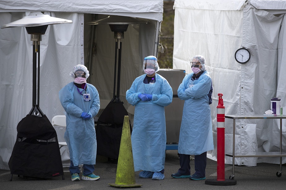 caption: UW Medicine nurses wait for patients to arrive to be tested for coronavirus on Tuesday, March 17, 2020, at the University of Washington Northwest Outpatient Medical Center drive-through testing area on Meridian Avenue North in Seattle. 