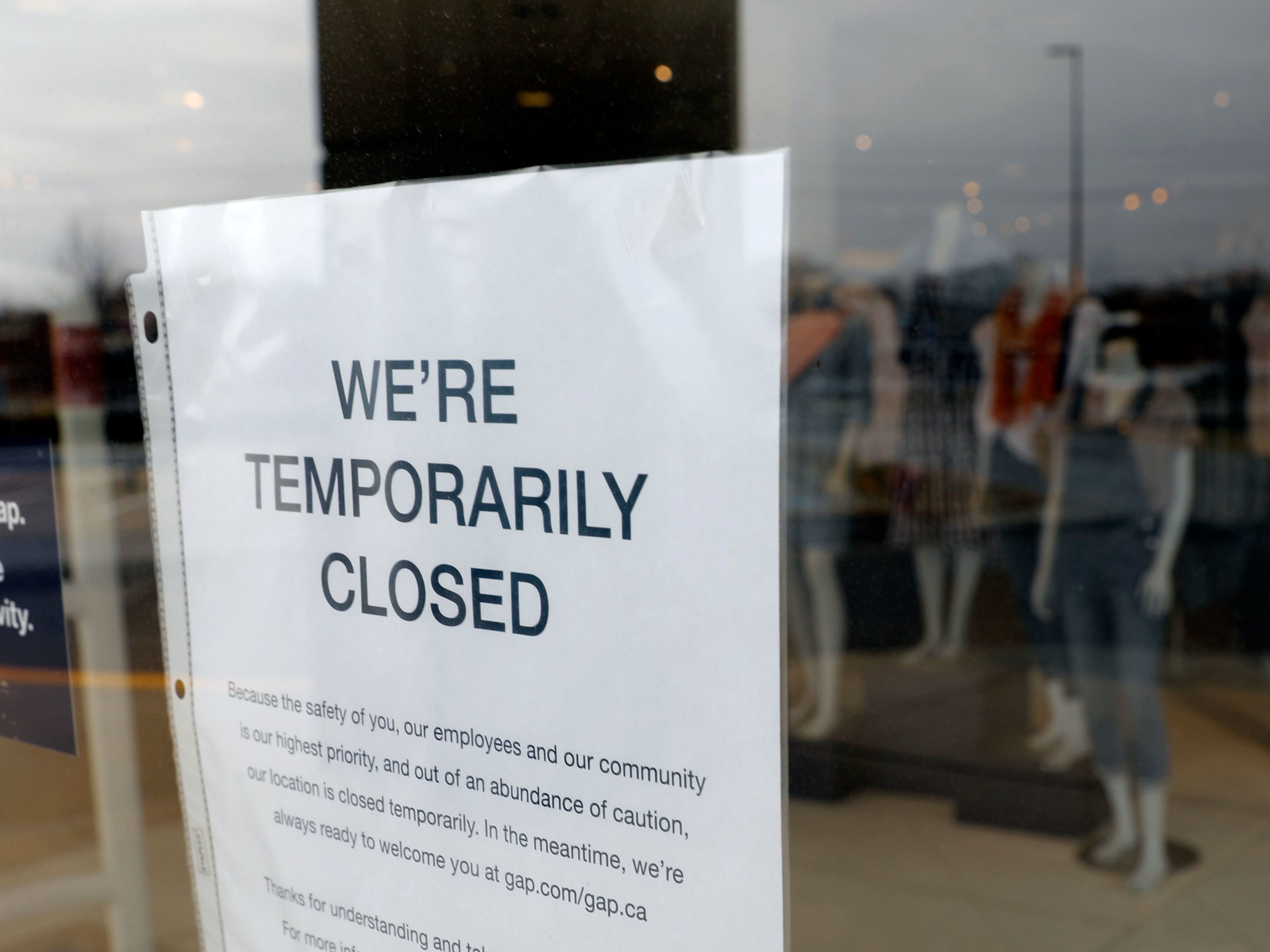 caption: A GAP store with a closed sign due to the COVID-19 outbreak in Farmington Hills, Michigan, in March 2020.