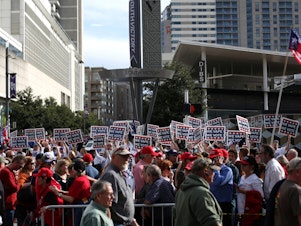 caption: Attendees hold "We Vape, We Vote" signs ahead of a Trump rally last month in Dallas. The politics surrounding vaping and industry pushback against regulation appear to have derailed the Trump administration's plan to ban the sales of many vaping products.