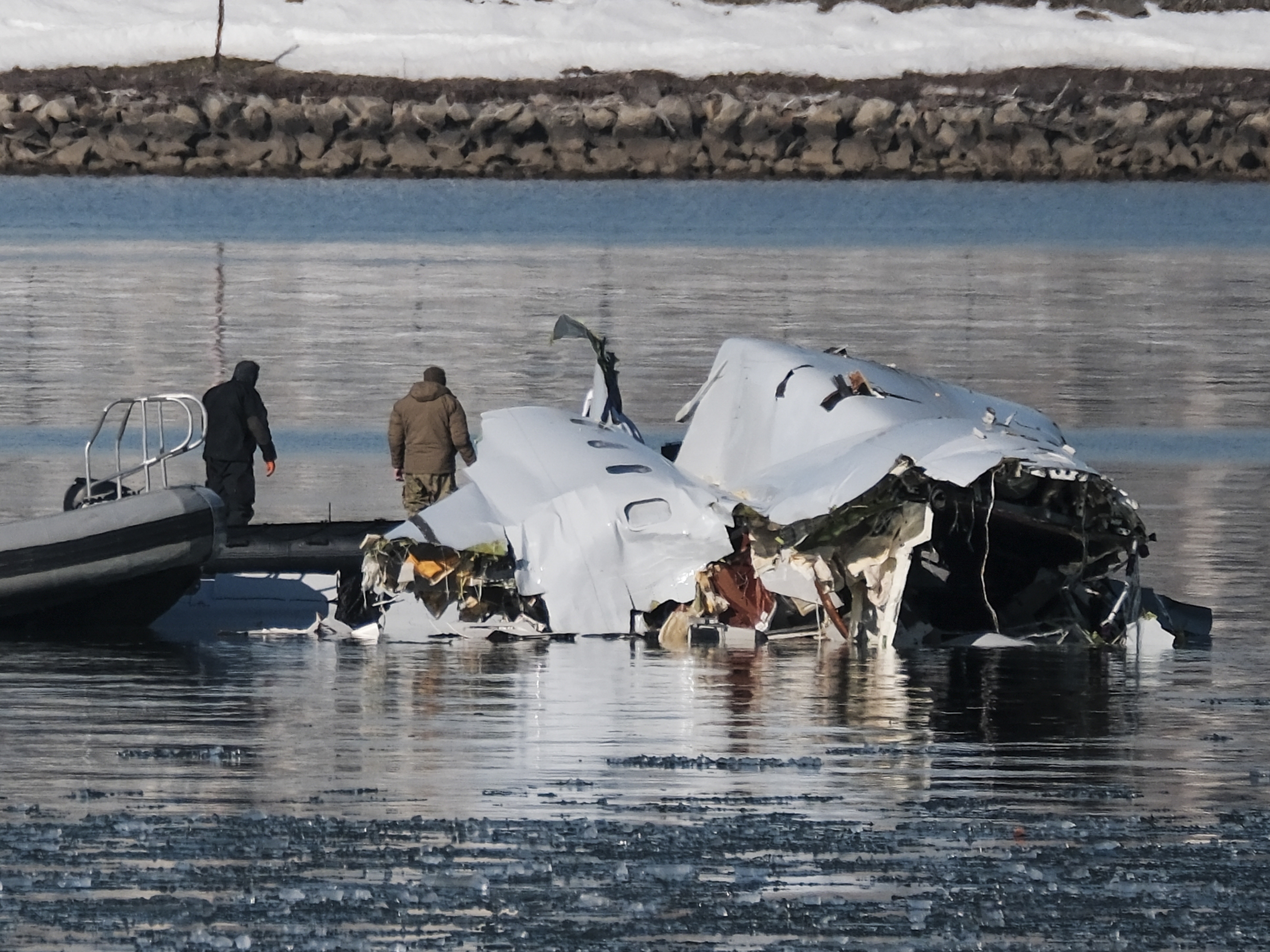 caption: First responders search the crash site of American Airlines Flight 5342 along the Potomac River near Ronald Reagan National Airport in Arlington, Va., on Thursday.