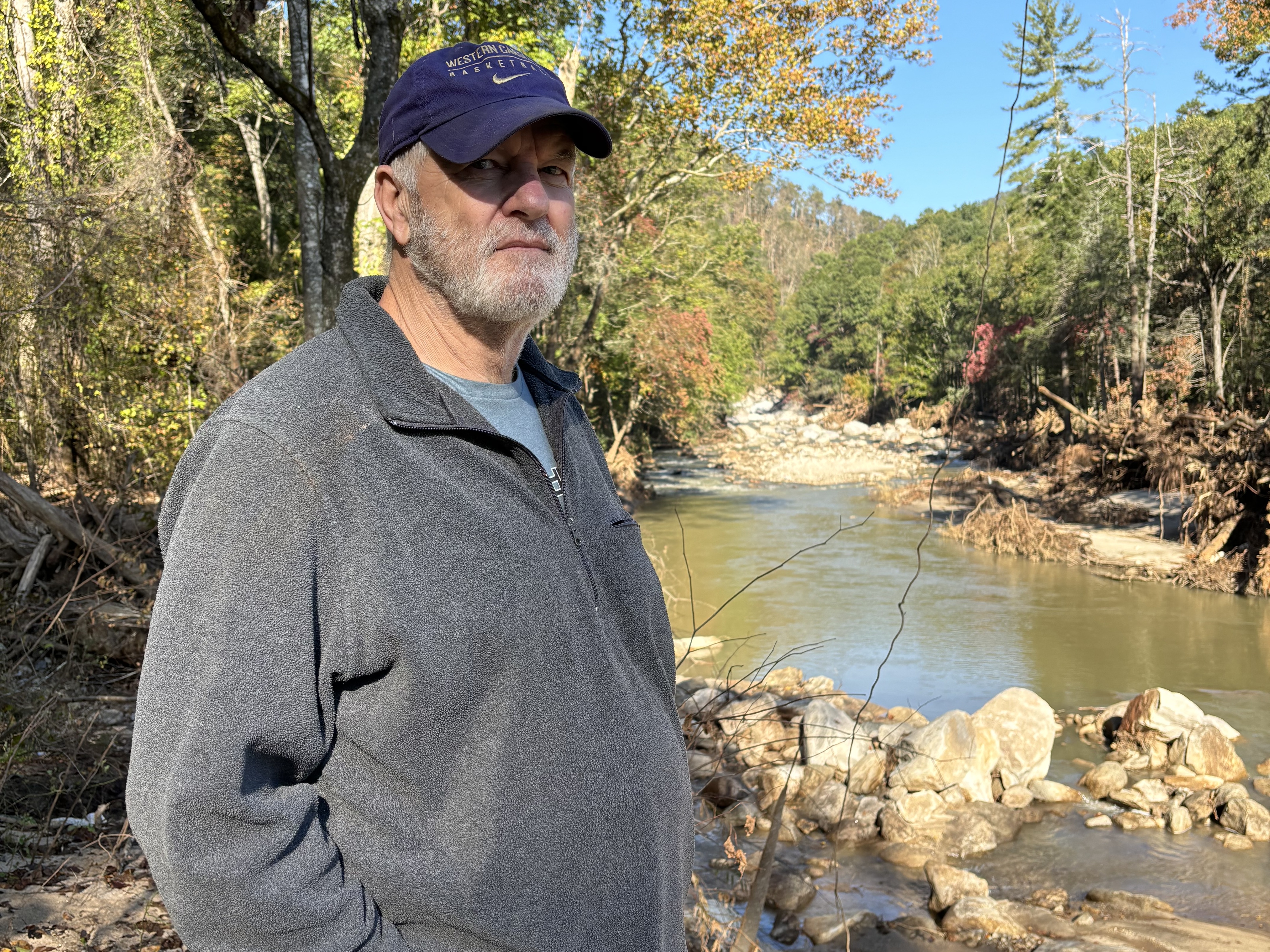 caption: Woody Callaway overlooks the Fish Top access to North Carolina’s Green River, a spot famous for kayaking, rafting and tubing that is now littered with debris and washed-up logs.
