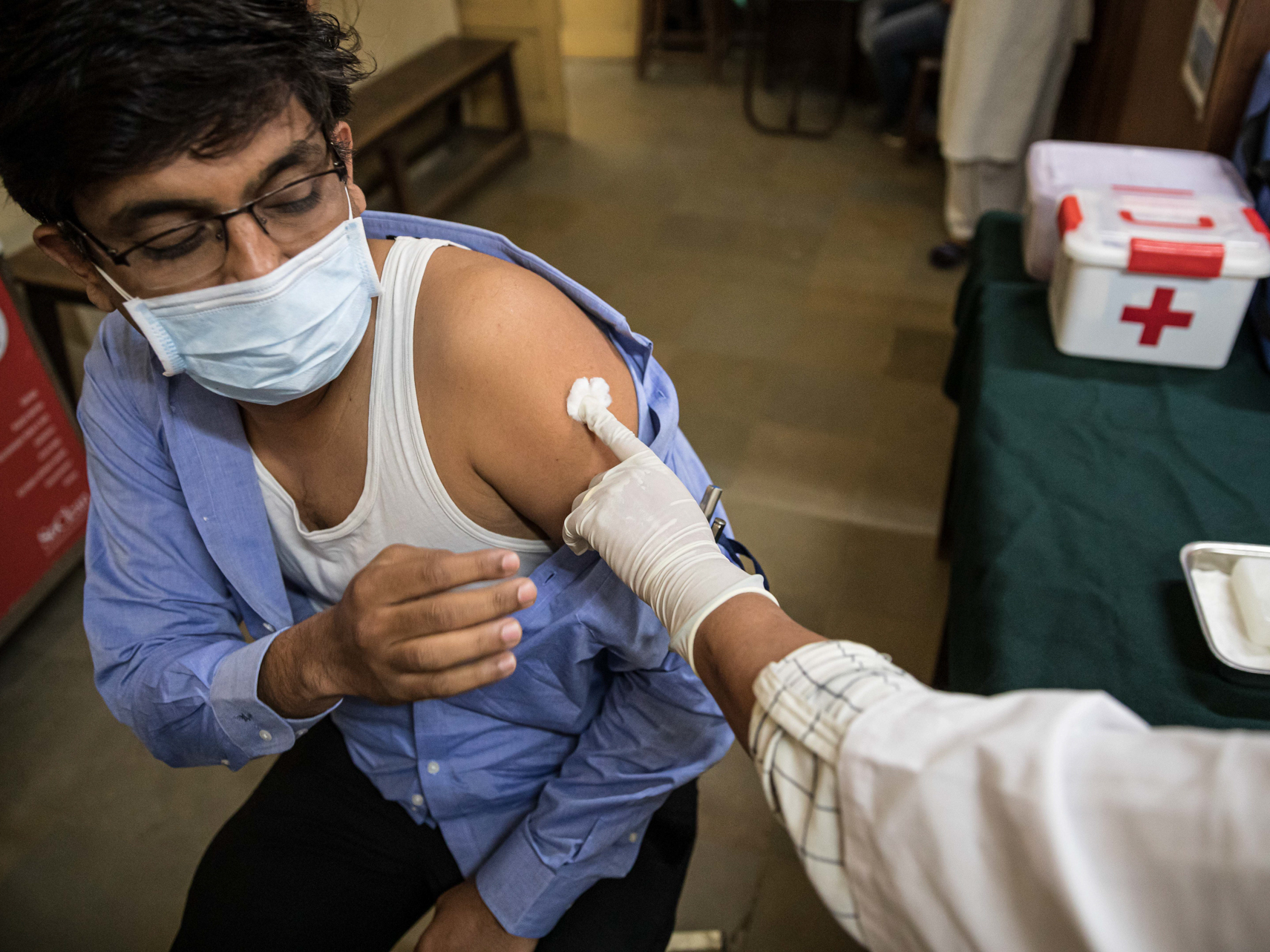 caption: Amit Sonawane, 35, an engineer at a district health office, gets his first vaccine dose in Palghar, India.