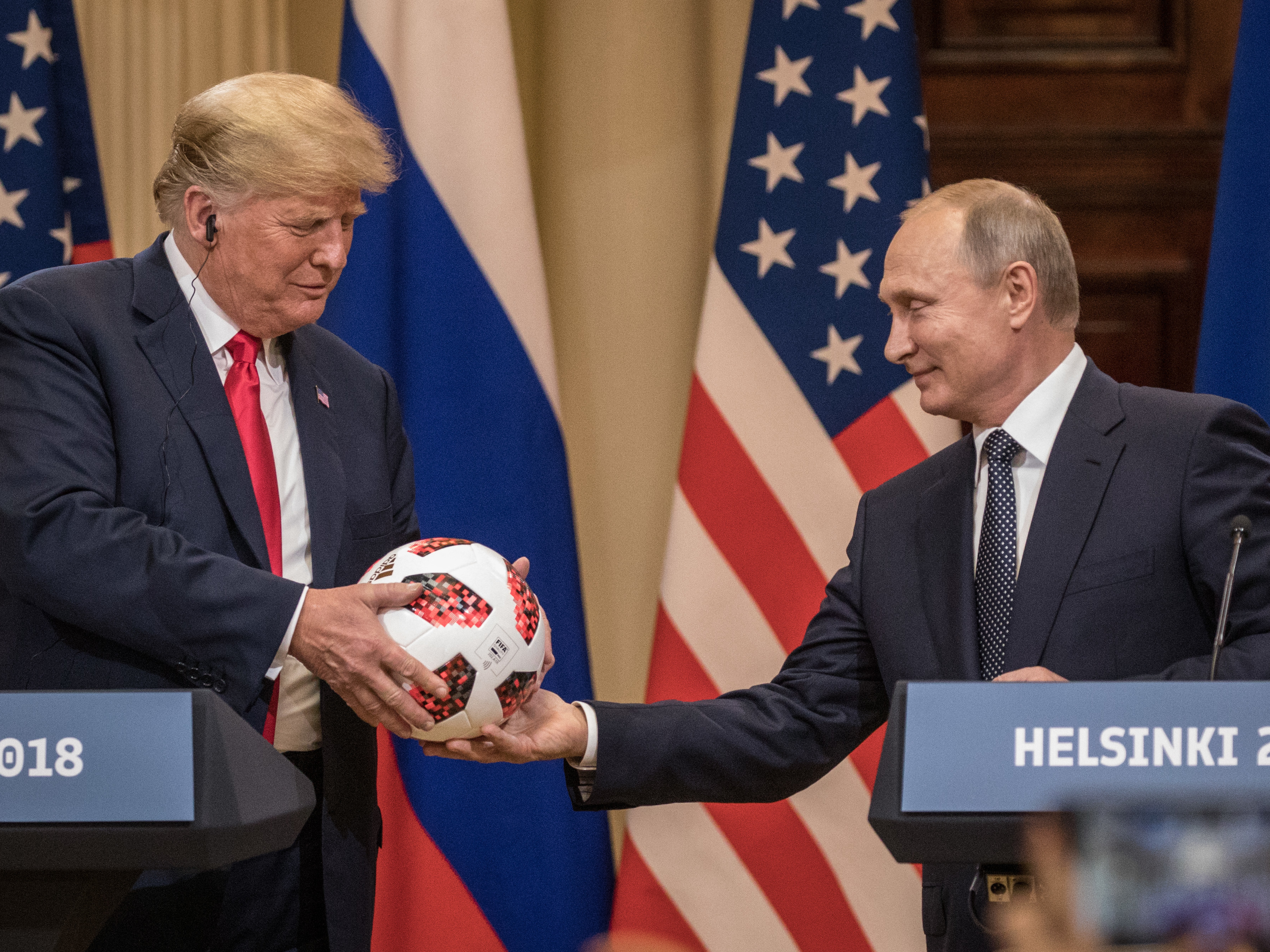 caption: Russian President Vladimir Putin hands President Trump a World Cup soccer ball during a joint news conference after their summit on July 16, 2018, in Helsinki.
