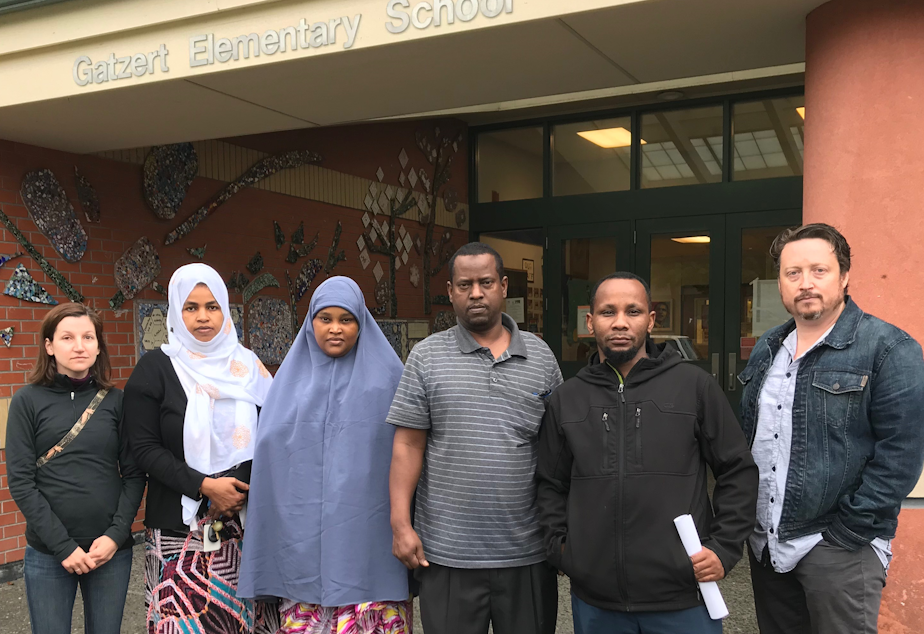 caption: Bailey Gatzert Elementary parents Amalia Icreverzi, Nimco Ahmed, Aisha Mohamed, Abu Mohamed, Ali Abdulaziz and Jaime Griesemer stood outside the school on June 24, 2019.