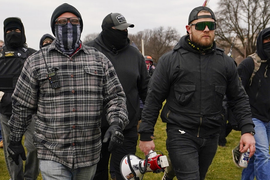 caption: Proud Boys Joseph Biggs, left, and Ethan Nordean, right with megaphone, walk toward the U.S. Capitol in Washington, D.C., on Jan. 6, 2021, in support of President Donald Trump. Both were arrested and charged in the wake of the Capitol riot. 