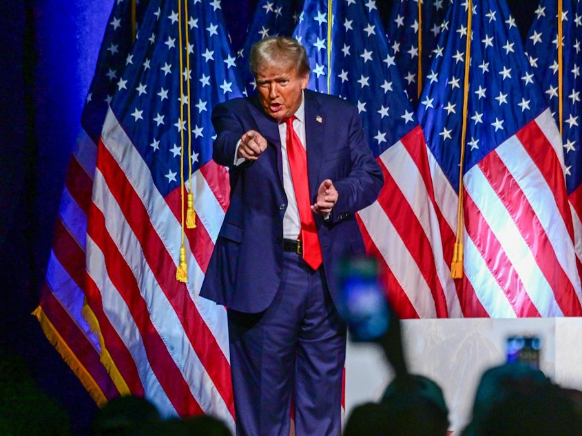 caption: Former president and 2024 Republican presidential hopeful Donald Trump gestures during a campaign event in West Palm Beach, Fla., on Oct. 11. He did not appear in nearby Fort Pierce for a court hearing the next day.