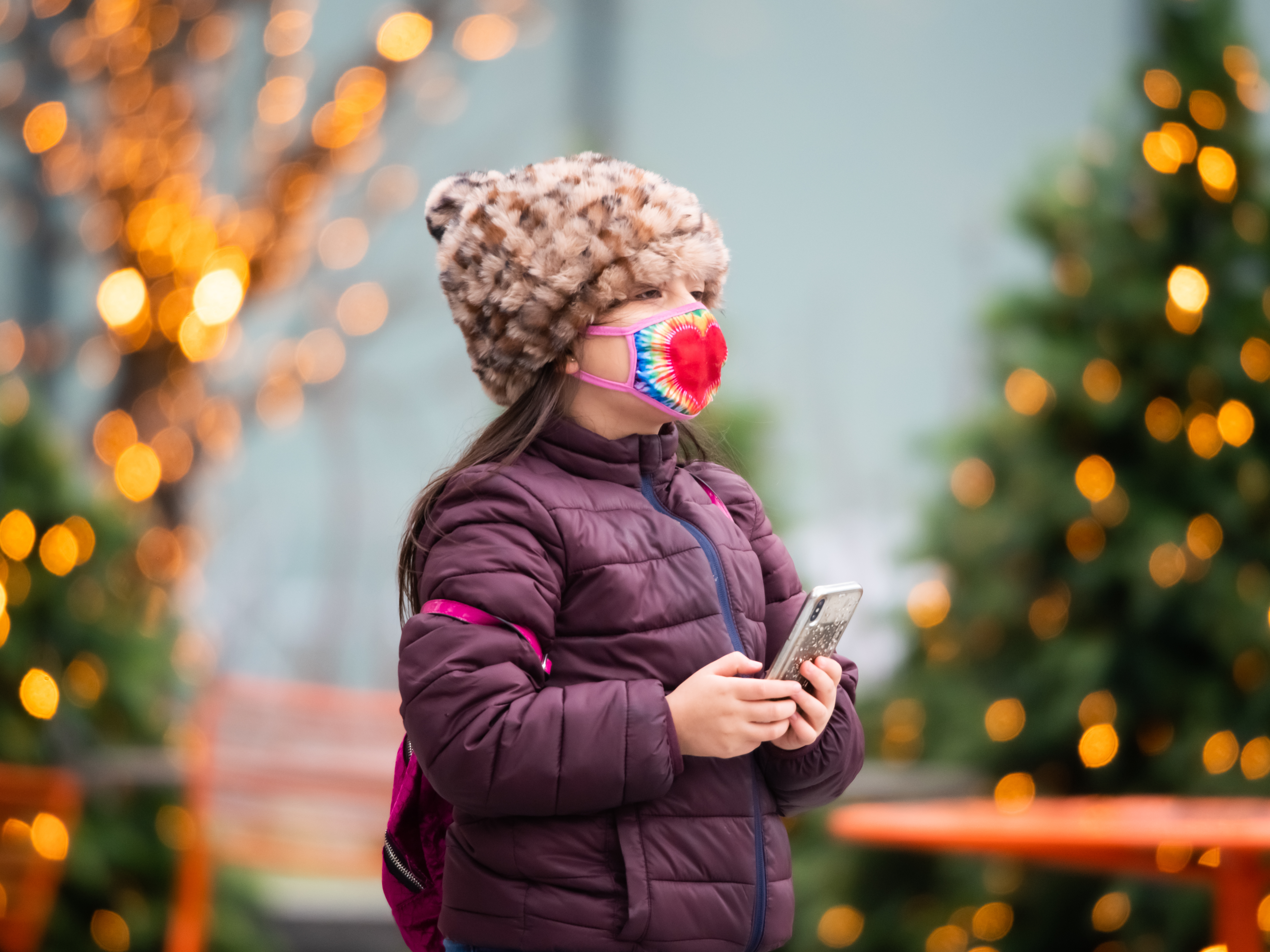 caption: Above, a child walks by a Christmas display in New York City last year. Dr. Anthony Fauci, the nation's top infectious disease expert, says it's "too soon to tell" whether Americans will be able to gather during the winter holidays.
