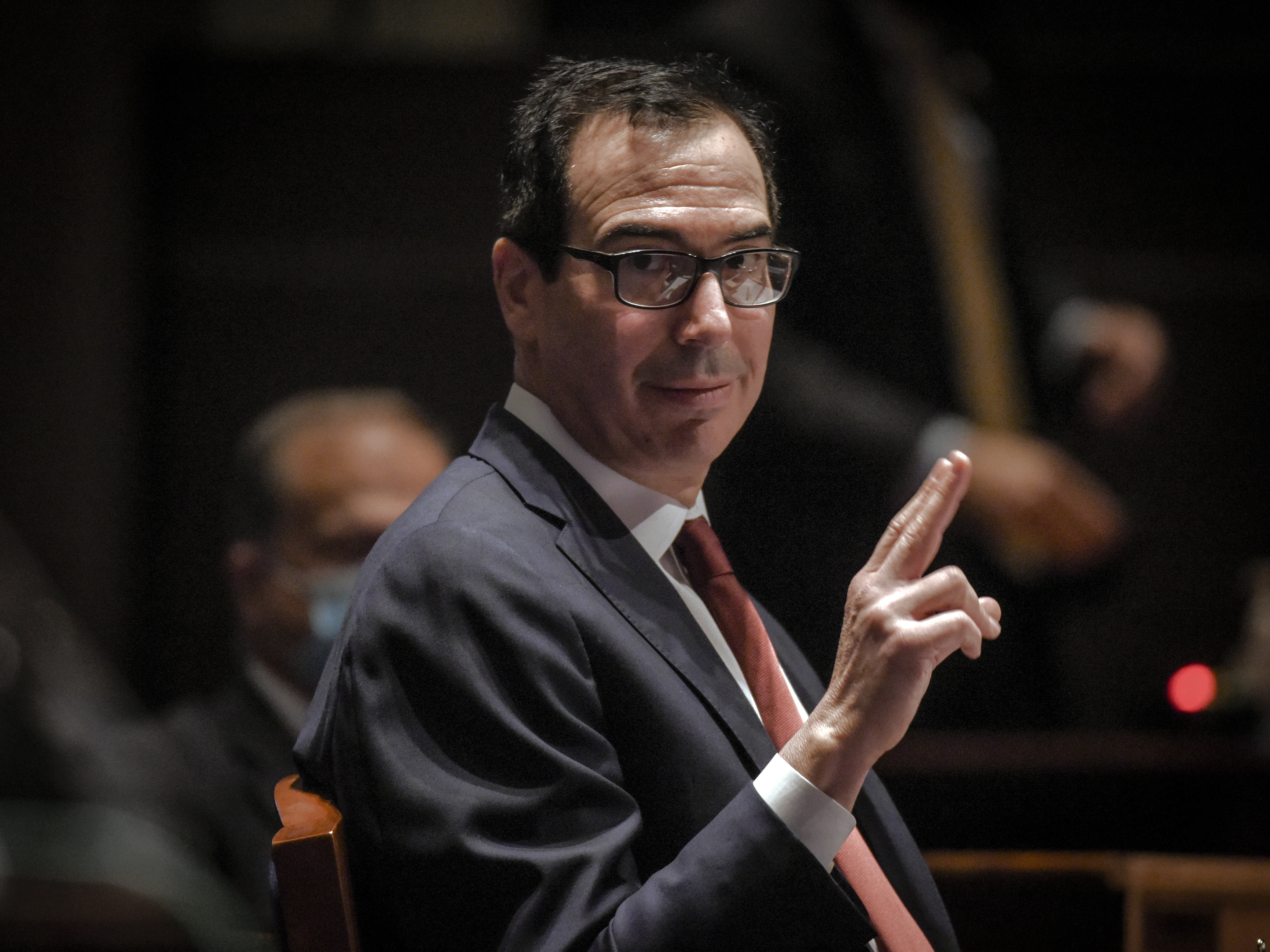 caption: Treasury Secretary Steven Mnuchin gestures toward Federal Reserve Board Chairman Jerome Powell, as they appear before a House Committee on Financial Services hearing on oversight of the Treasury Department and Federal Reserve pandemic response, on Tuesday in Washington.
