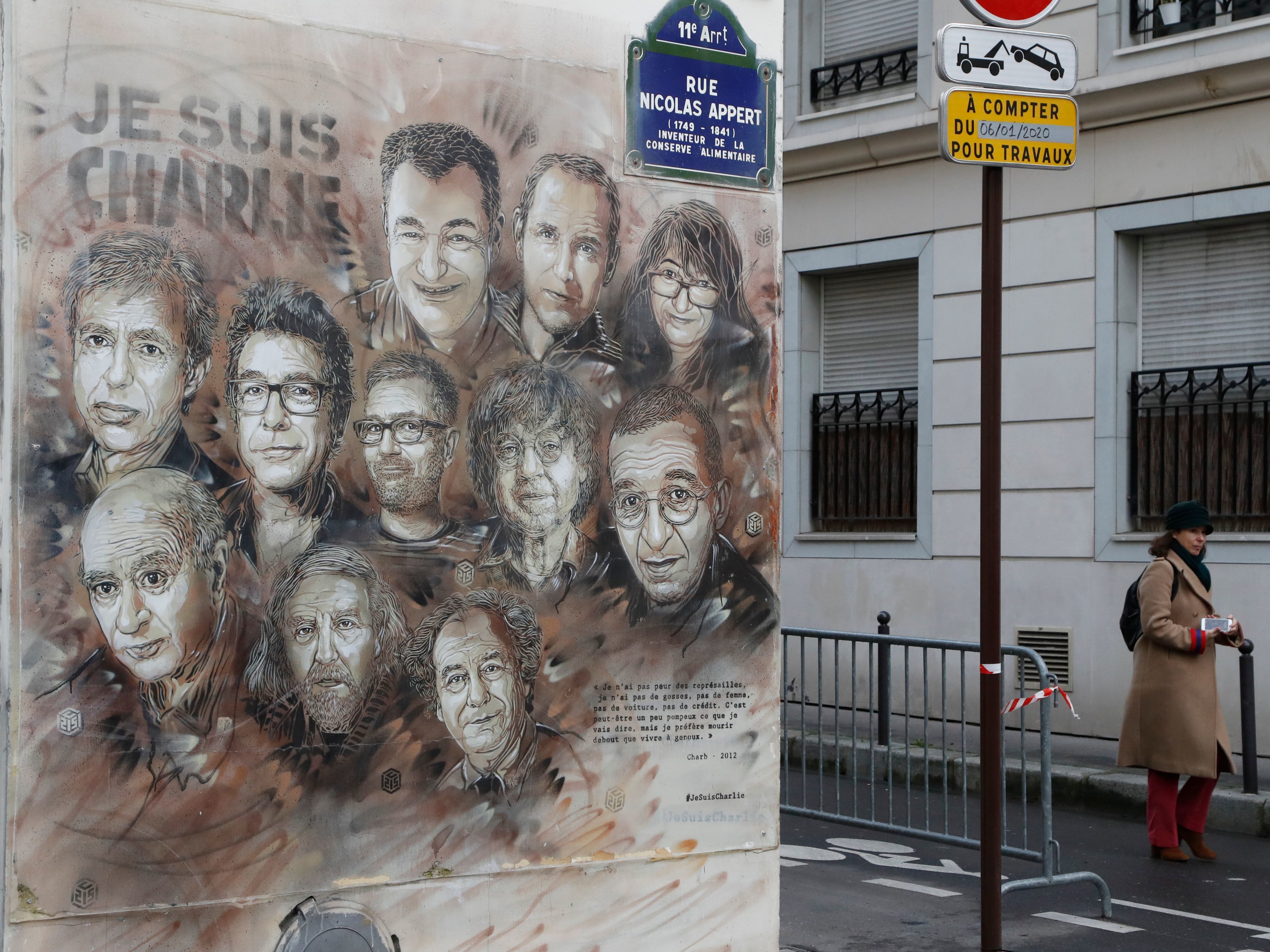 caption: The work of French street artist Christian Guemy aka "C215" depicting members of satirical magazine <em>Charlie Hebdo</em> is painted on a facade near the magazine's offices at Rue Nicolas Appert in Paris, to commemorate the fifth anniversary of the attack of the magazine that killed 12 people.