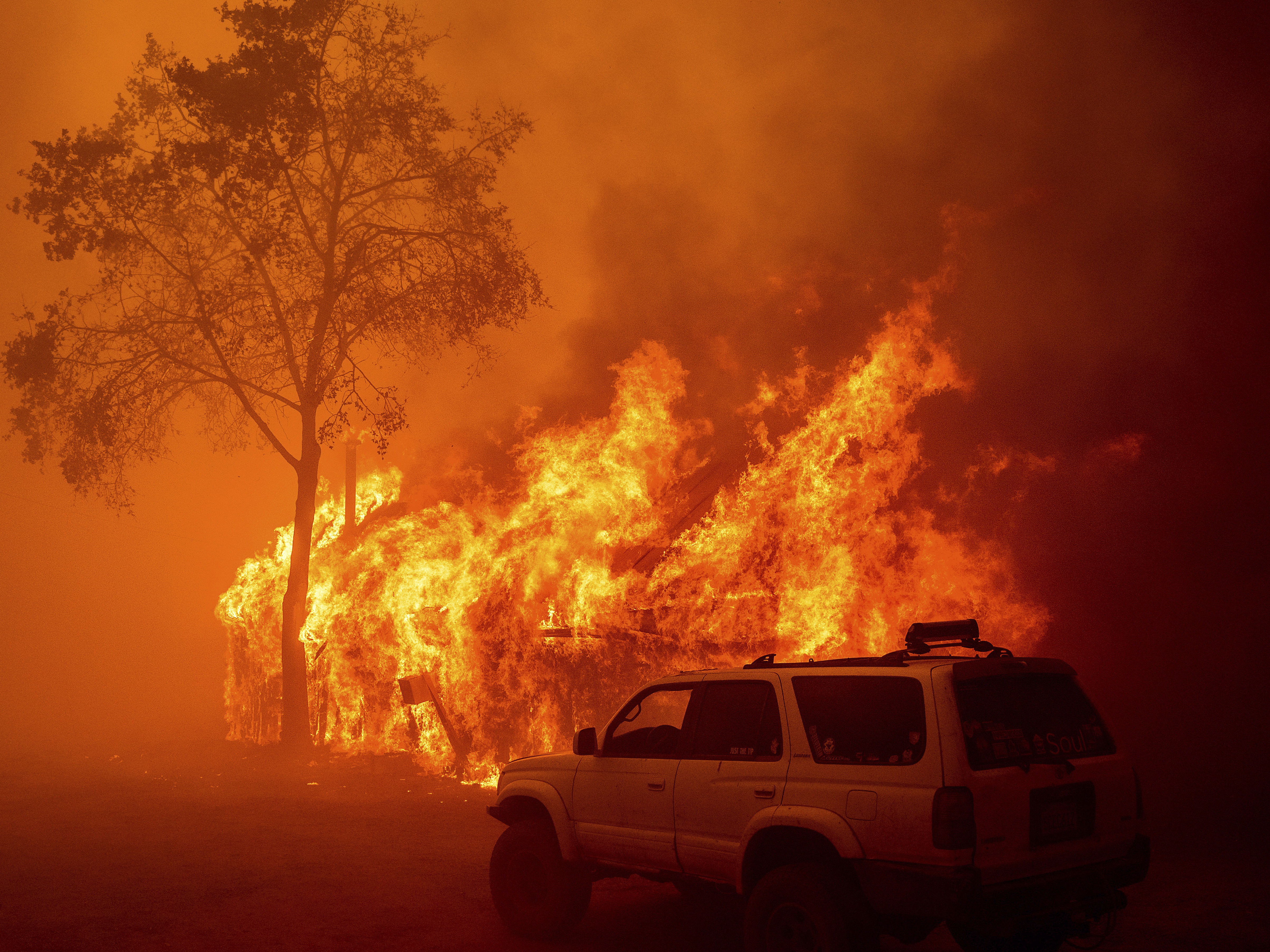 caption: Flames consume a building as the Park Fire tears through the Cohasset community in Butte County, Calif., on Thursday.