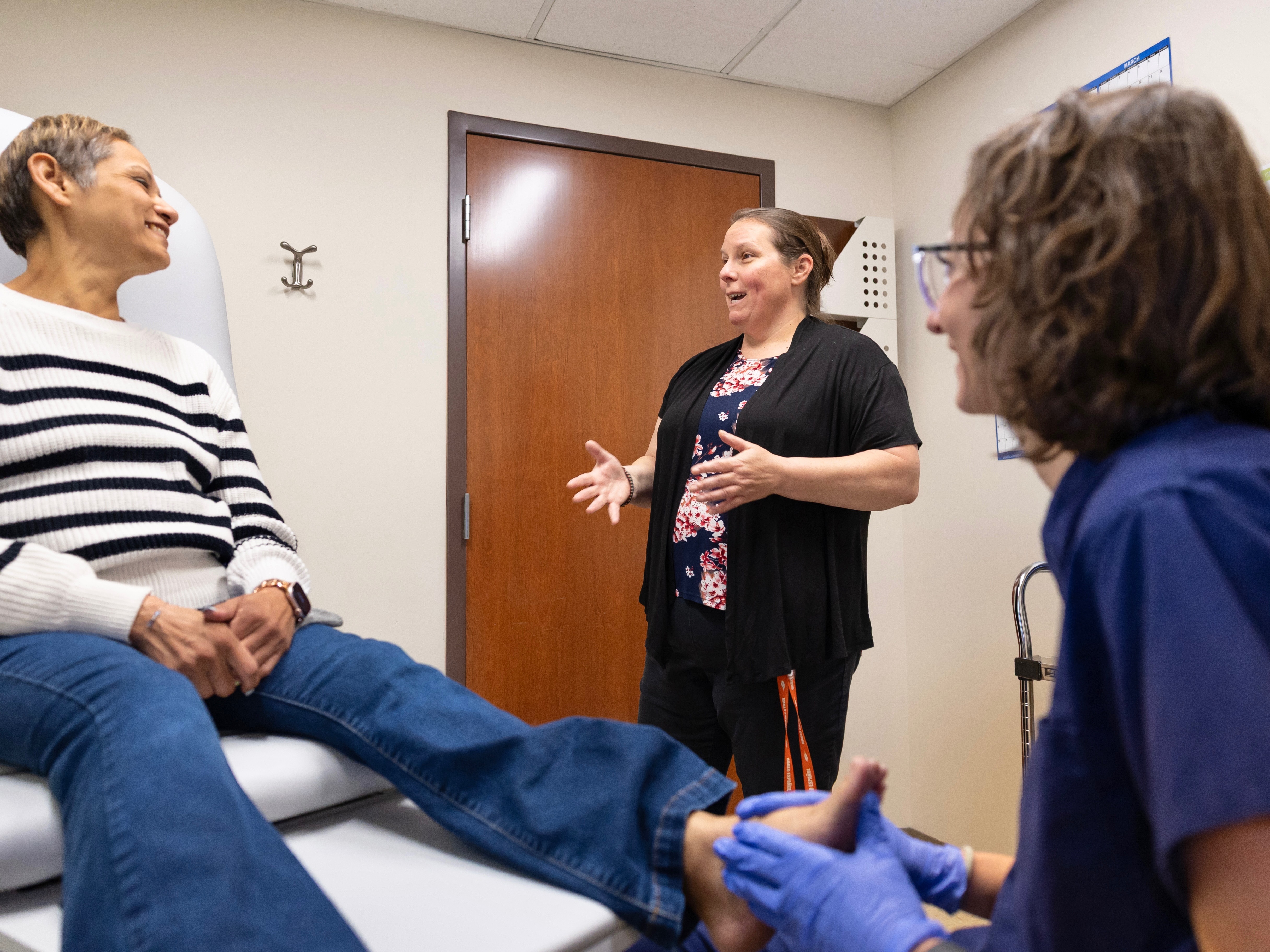 caption: Jen Quevedo, center, serves as a medical interpreter for a patient at Grand River Health in Rifle, Colo. Quevedo now serves as the hospital's language access coordinator.