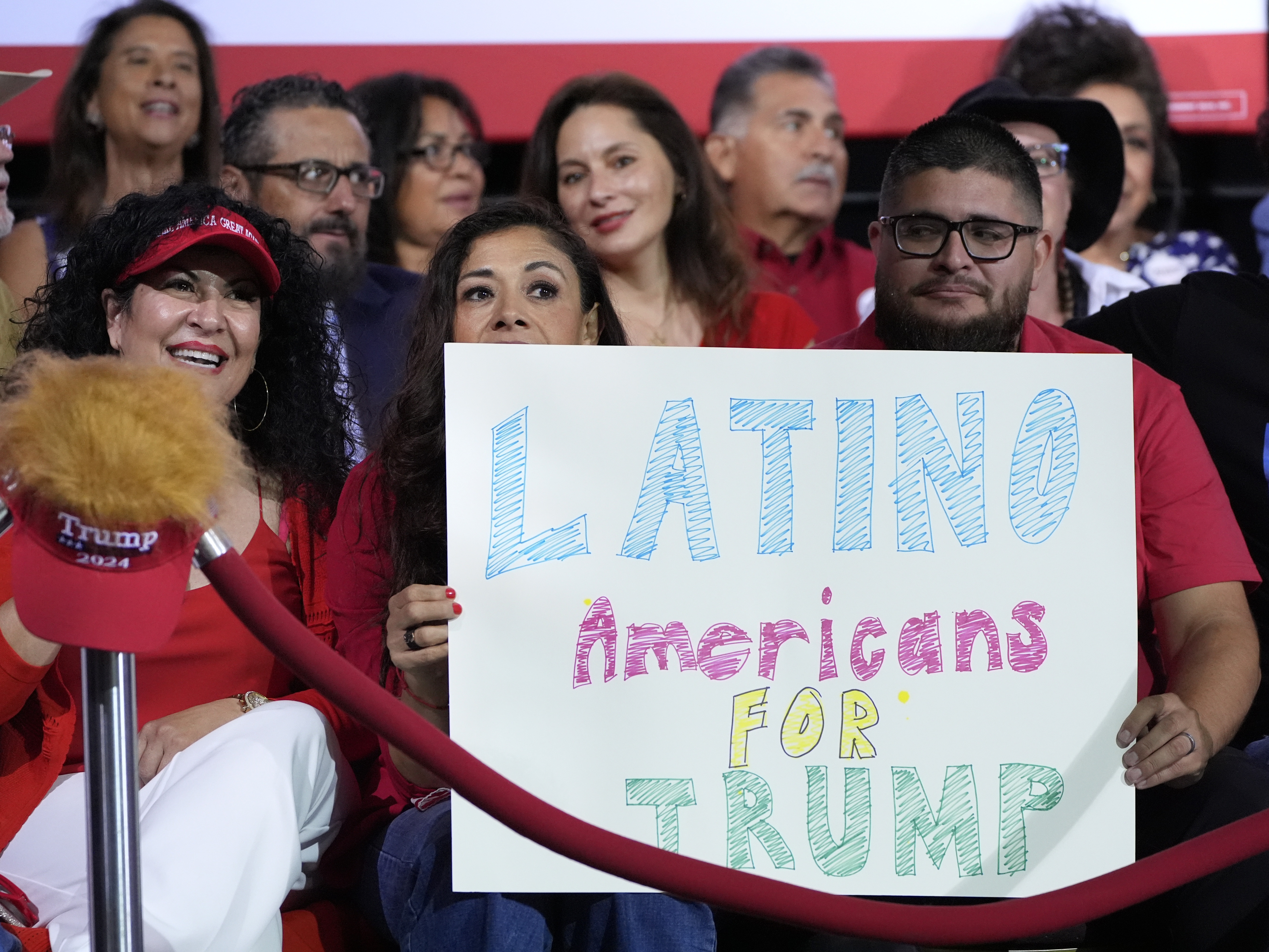 caption: Supporters hold a sign before Republican presidential nominee former President Donald Trump arrives to speak during a campaign event, Sept.12, in Tucson, Ariz.