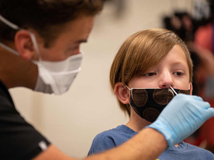 caption: A nurse tests a student for COVID-19 at Brandeis Elementary School in Louisville, Ky.