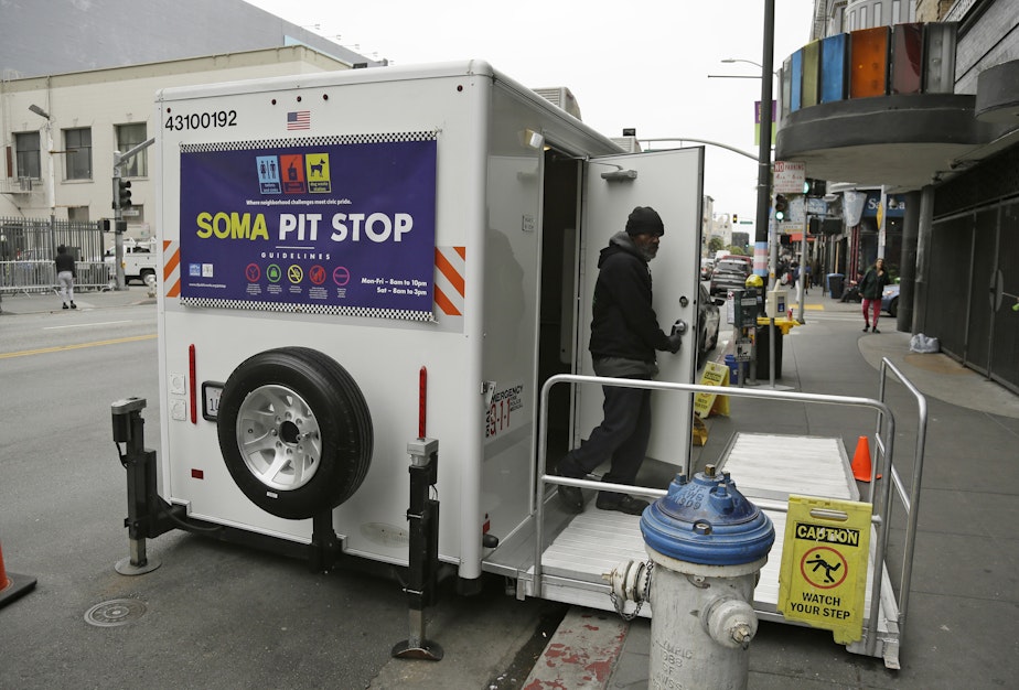 caption: An attendant exits a 'Pit Stop' public toilet on Sixth Street, Thursday, Aug. 1, 2019, in San Francisco. A 5-year-old portable toilet program in San Francisco that provides homeless people with a private place to go has expanded to 25 locations in the city and has spread to Los Angeles.
