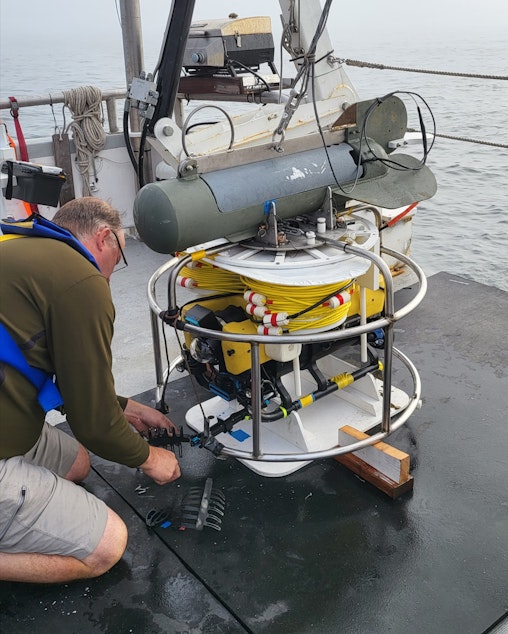 caption: Jeff Hummel readies the ROV (remote operated vehicle) to deploy down to the wreck site.