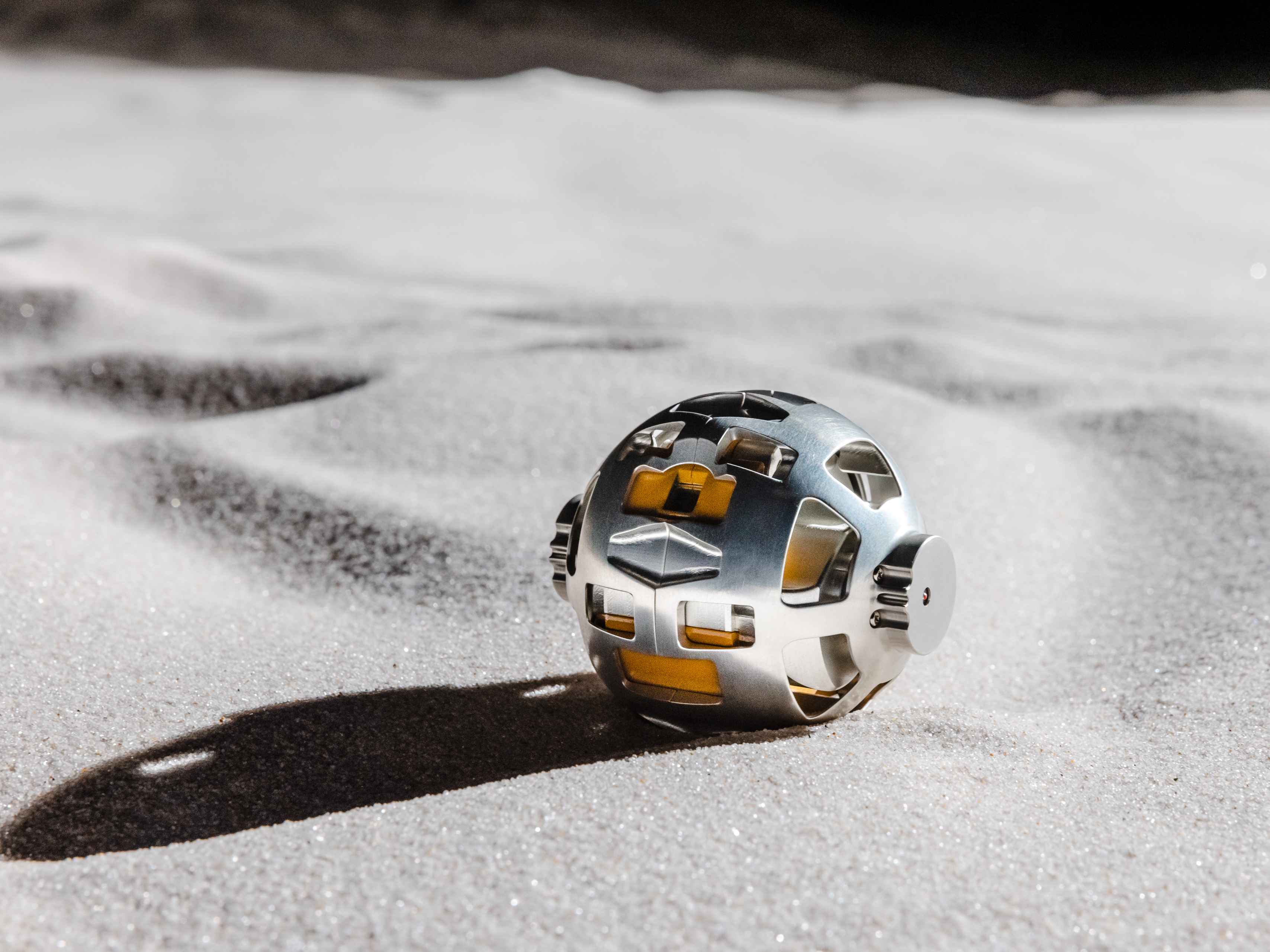 caption: The SORA-Q robot is a sphere that can split and elongate, allowing it to traverse the moon's surface.