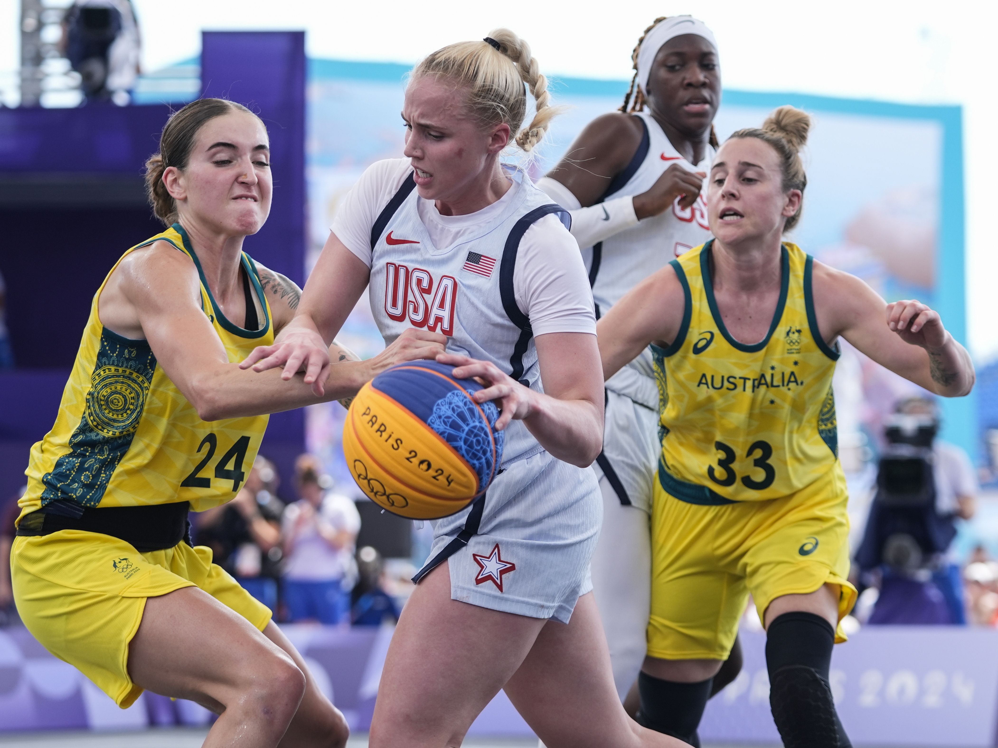 caption: Australia's Anneli Maley (24) and Lauren Mansfield (33) defend Hailey van Lith, of the United States, in the women's 3x3 basketball pool round match Thursday during the 2024 Summer Olympics in Paris. Australia won 17-15.