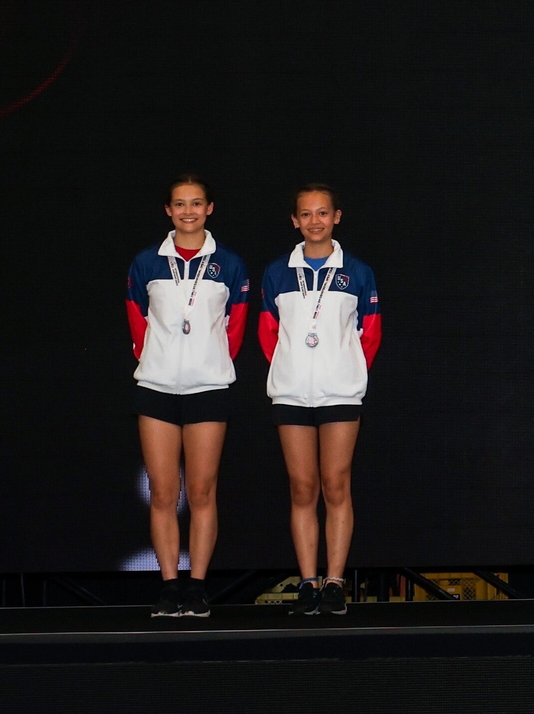 caption: Sisters Madeleine and Mara Garrison pose with their second place medals at the International Jump Rope Union's World Championships in August 2025.