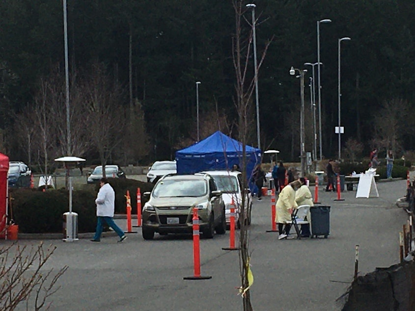 caption: On Saturday, Providence Olympia opened a drive-through COVID-19 testing site for symptomatic high-risk patients. Testing capacity in Washington has been hampered by a shortage of testing supplies and personal protective equipment.