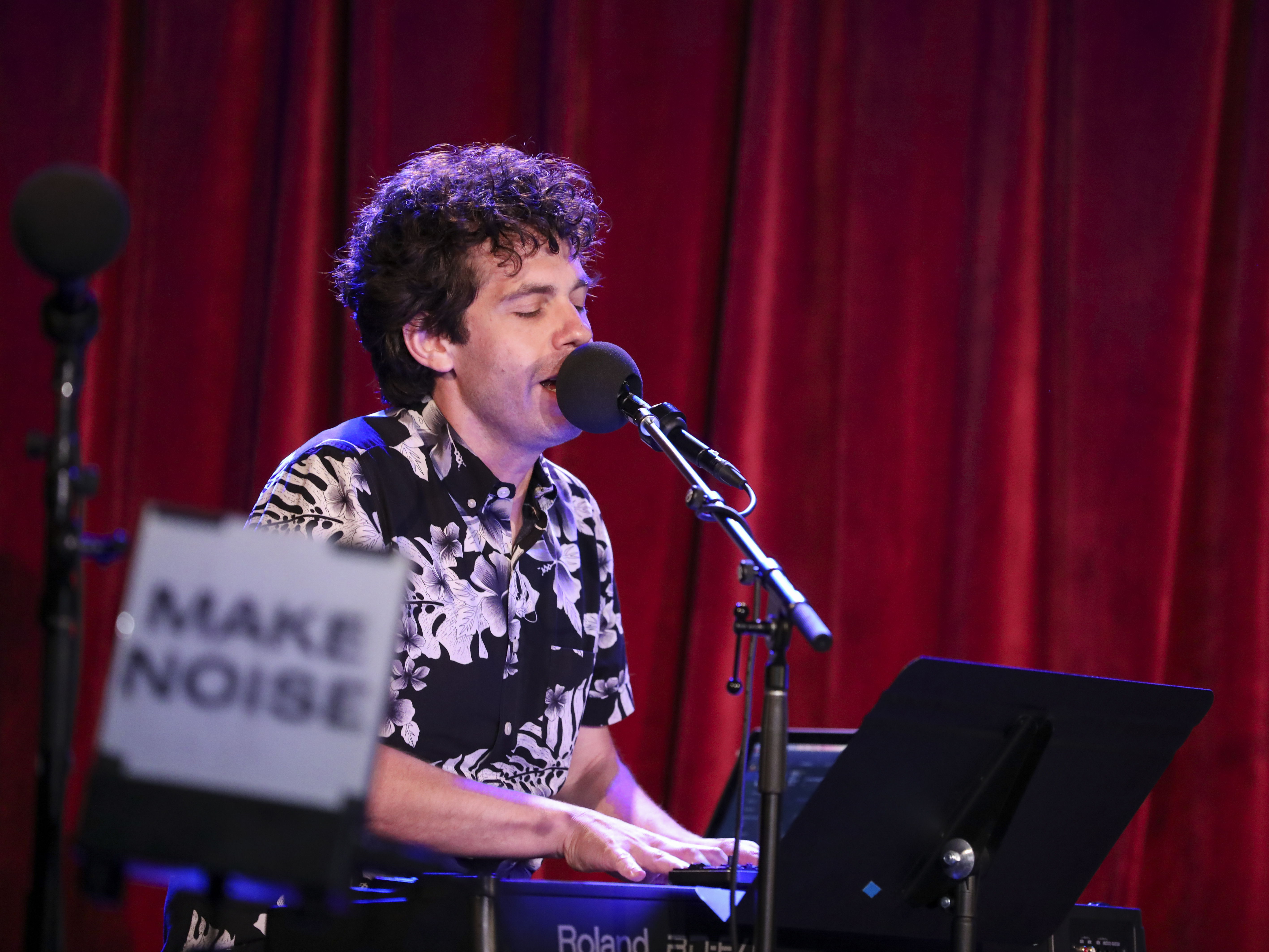 caption: <em>Ask Me Another</em>'s guest house musician Julian Velard leads a music parody game at the Bell House in Brooklyn, New York.