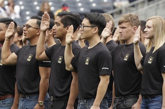 caption: New Army recruits take part in a swearing-in ceremony on June 4, 2017, in San Diego.