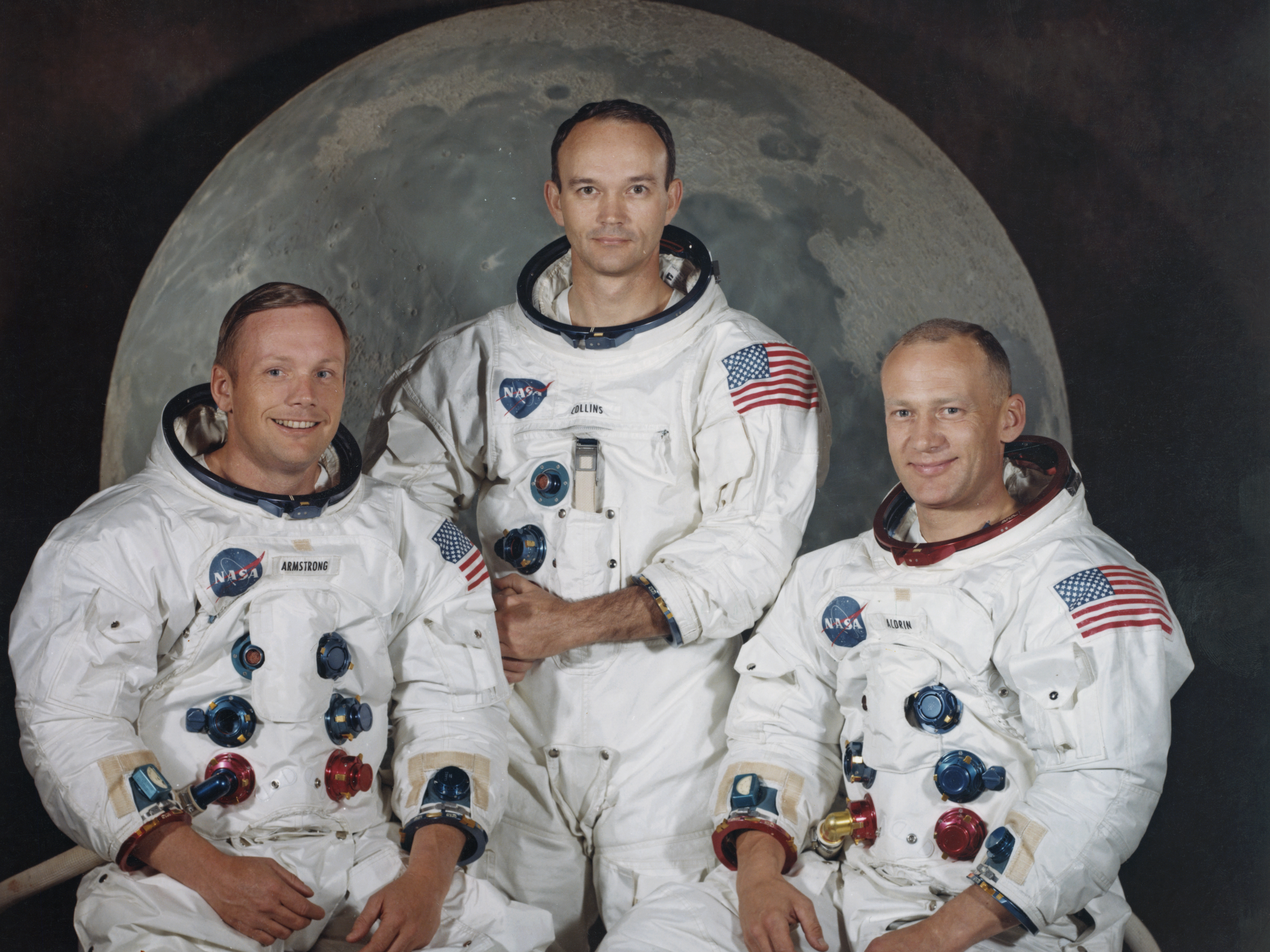 caption: Michael Collins, center, poses with Neil Armstrong, left, and Edwin "Buzz" Aldrin Jr. for a group portrait a few weeks before they took off to the moon in the Apollo 11 mission in 1969.