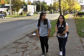 caption: Emily Au, right, a junior at Rainier Beach High School, walks home from school with her cousin, Rebecca Chung. Au says the walk is dangerous, and that some students skip class or show up tardy because they don't want to walk in the dark.