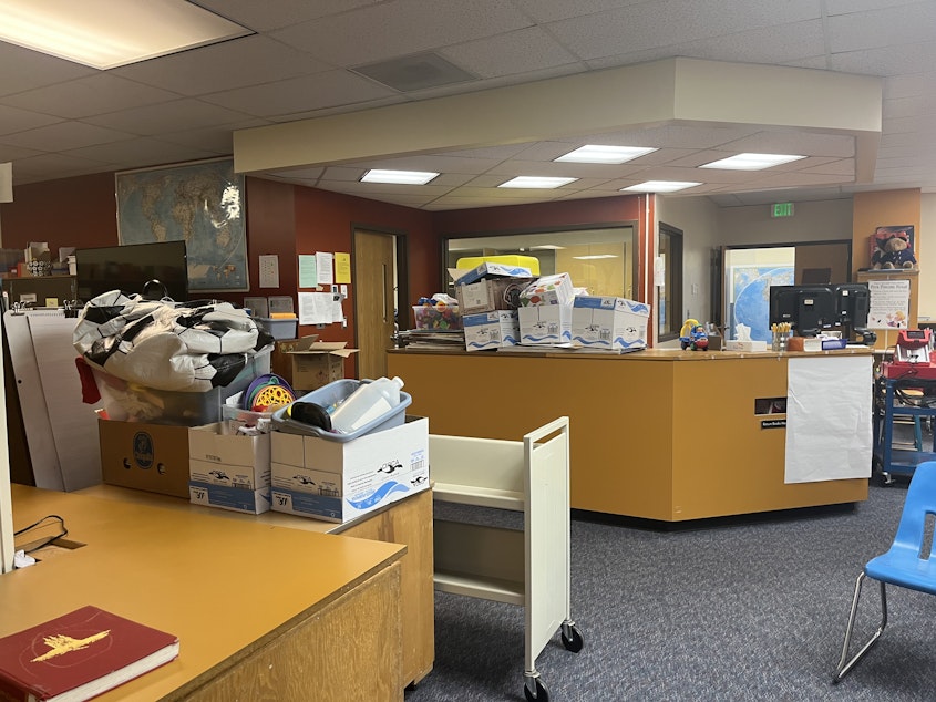 caption: As schools across the nation and state grapple with large budget deficits, a growing number of school libraries are no longer staffed — including at Concrete Elementary, where the librarian's old desk is now covered in boxes.